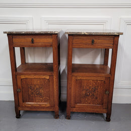 Pair of French Oak Arts & Crafts style marble top bedside cabinets. They have lovely carvings on the door, an open shelf in the middle and drawer at the top. They are in good original detailed condition.