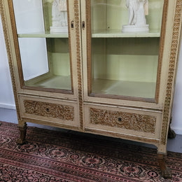 19th Century painted and gilt two door vitrine. Has one adjustable shelf and two drawers. In good original detailed condition.