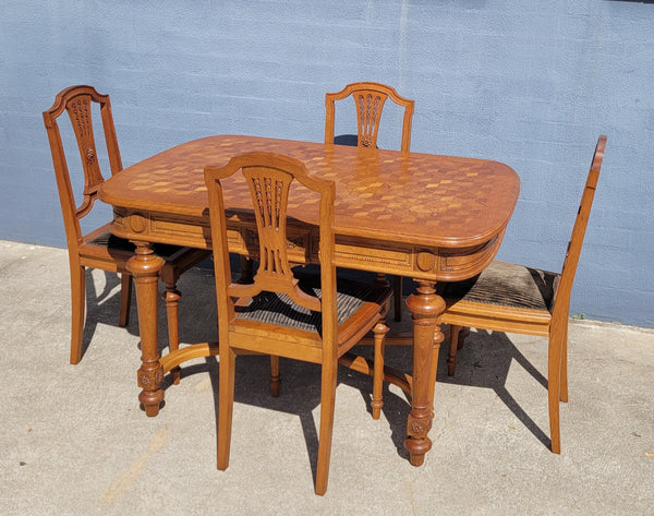 Beautiful carved French Oak dining table with a parquetry top and six matching upholstered chairs. All in good original detailed condition.