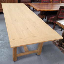 French raw Oak stretcher based refectory table. Features raw wood that could be used as is for a distressed look, or finished and waxed for a more refined look. Sourced from France and in good original condition.