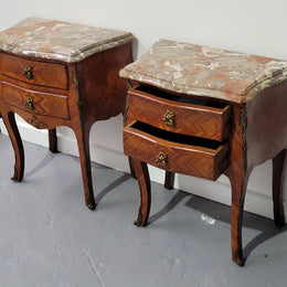 Pair of Louis XV commode style two drawer bedsides with beautiful marble tops and decorative mounts. They are a rare size and are in good, detailed condition.