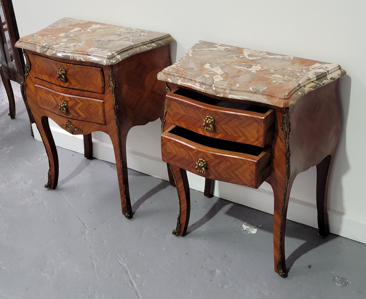 Pair of Louis XV commode style two drawer bedsides with beautiful marble tops and decorative mounts. They are a rare size and are in good, detailed condition.