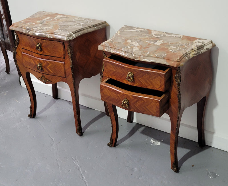 Pair of Louis XV commode style two drawer bedsides with beautiful marble tops and decorative mounts. They are a rare size and are in good, detailed condition.
