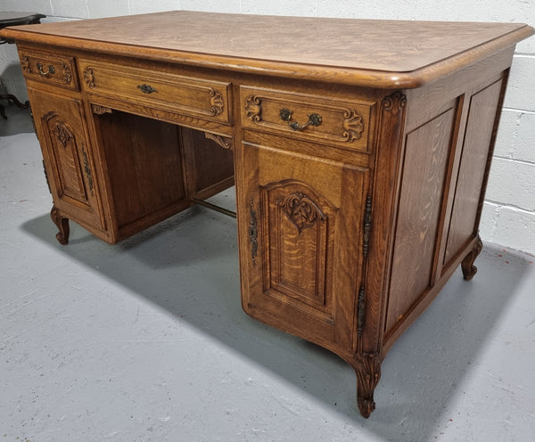 Fabulous French oak carved partners desk with a lovely parquetry top. It has three drawers and two cupboards on one side and two cupboards on the other side with no functioning drawers. It is in good original detailed condition.