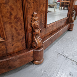 An elegant Antique Victorian Burr wood Walnut marble-top sideboard credenza with a mirrored center door. It has a white shaped marble top, mirror front, nicely carved details and three swing doors along with two keys. It is in good original detailed condition.