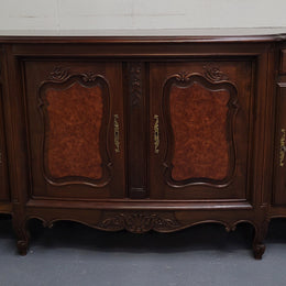 Fabulous Louis XV style French Walnut and Burr Walnut four door sideboard. Each door panel has beautiful Burr Walnut panels and open up to an adjustable shelf. Beautiful handles and two drawers for added storage. In good original detailed condition.