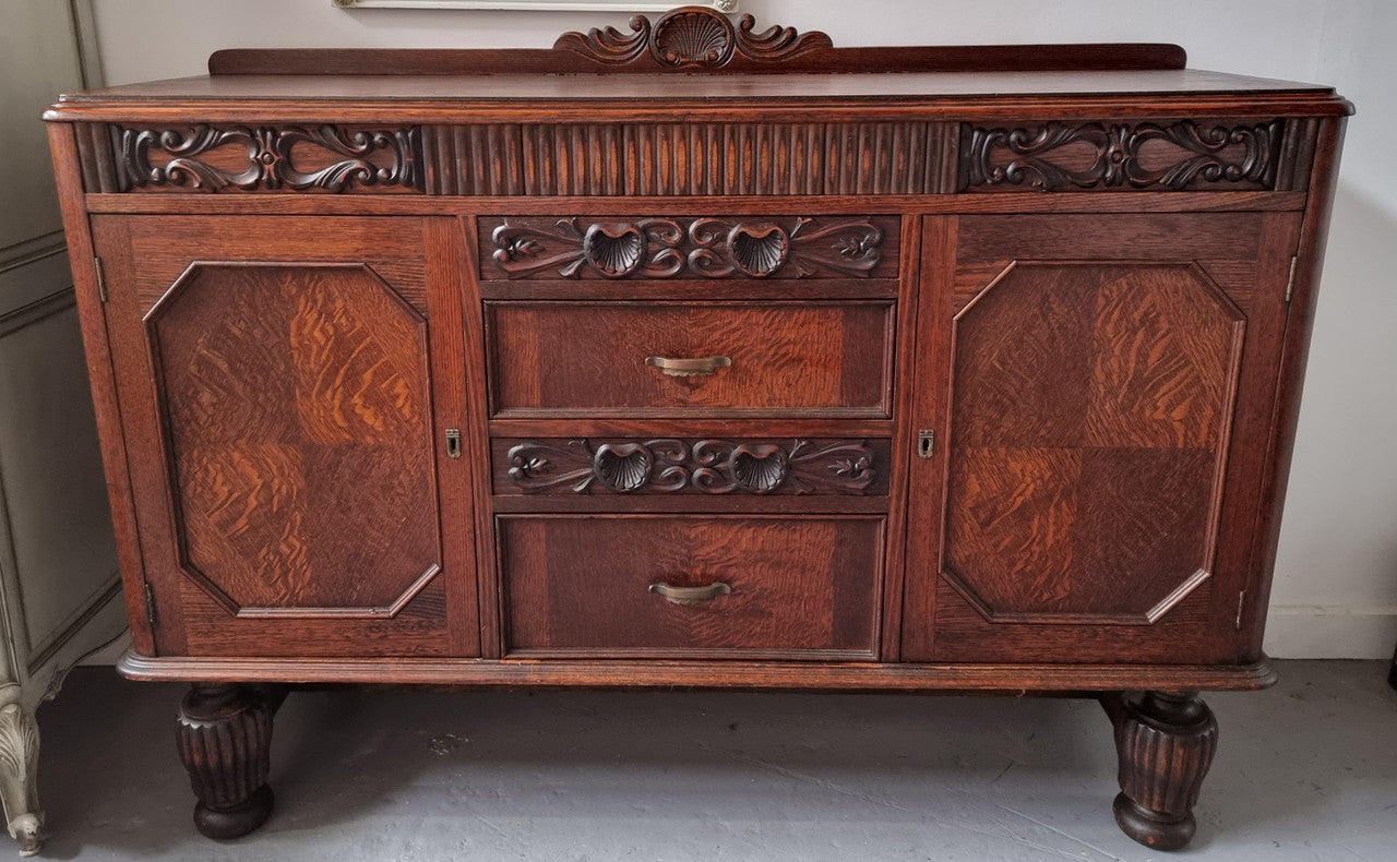 Art Deco Tudor style Oak sideboard with decorative carved detail. Plenty of storage space with two cupboards and four drawers. It has been sourced locally and is in good original detailed condition.