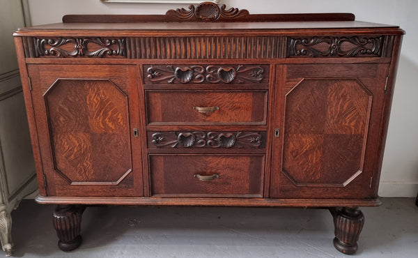 Art Deco Tudor style Oak sideboard with decorative carved detail. Plenty of storage space with two cupboards and four drawers. It has been sourced locally and is in good original detailed condition.