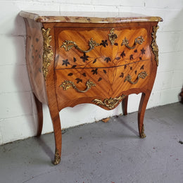 Charming petite French Louis XV style commode featuring two drawers, marquetry inlay, ormolu trim and marble Top. In good original detailed condition.  Circa: 1930’s.