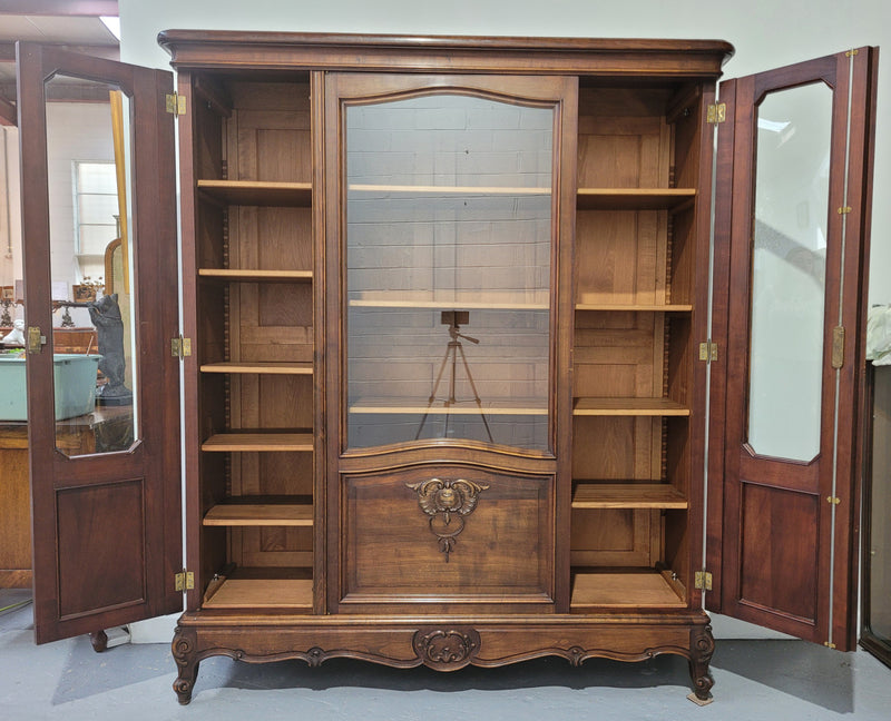 French Louis XV style walnut three door bookcase. It has adjustable shelves and is in good original detailed condition.