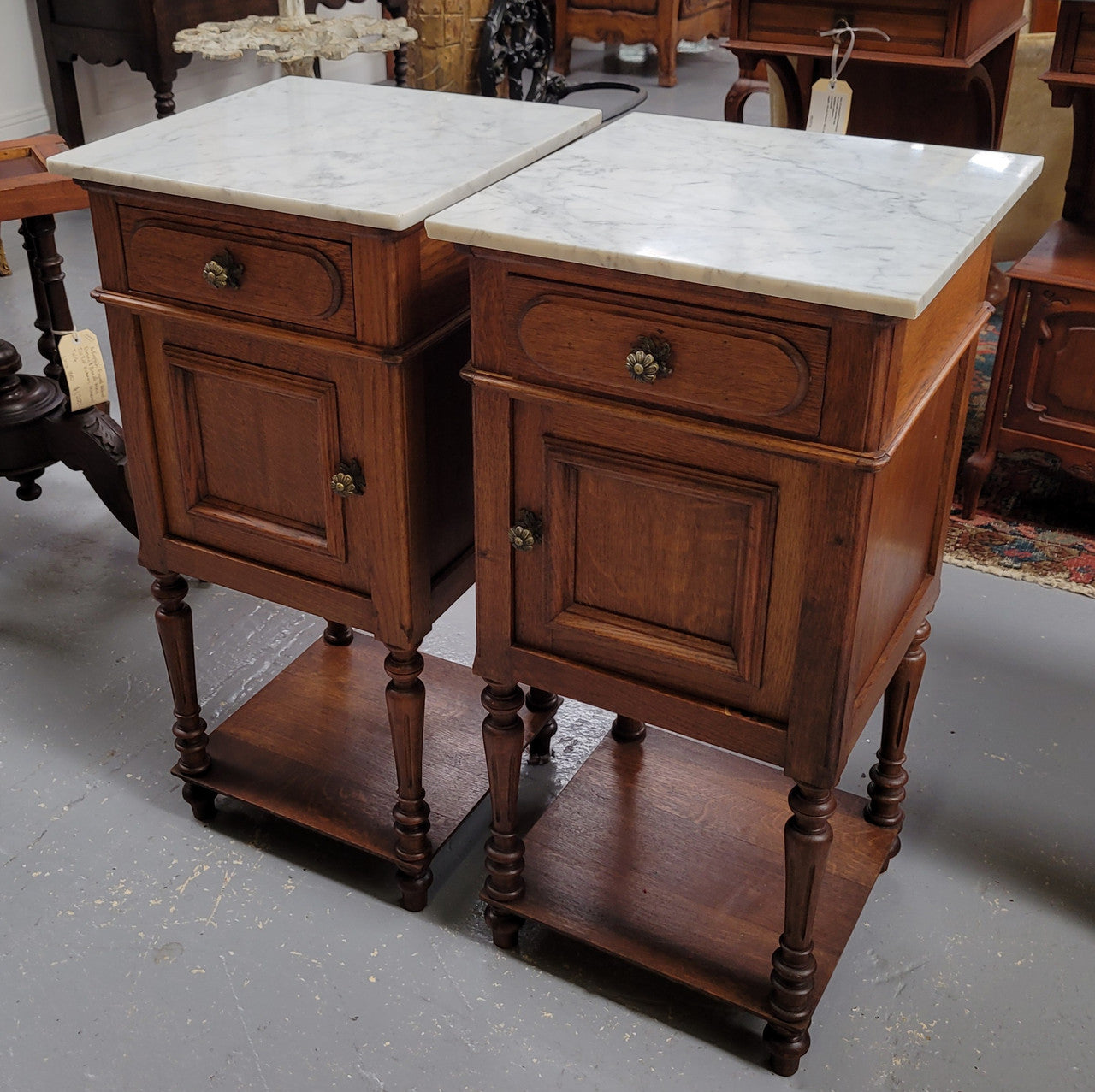 Antique French Oak Henry II white marble top bedside cabinets. They have one drawer and cupboard a long with an open shelf at the bottom. Sourced from France and in good original detailed condition.