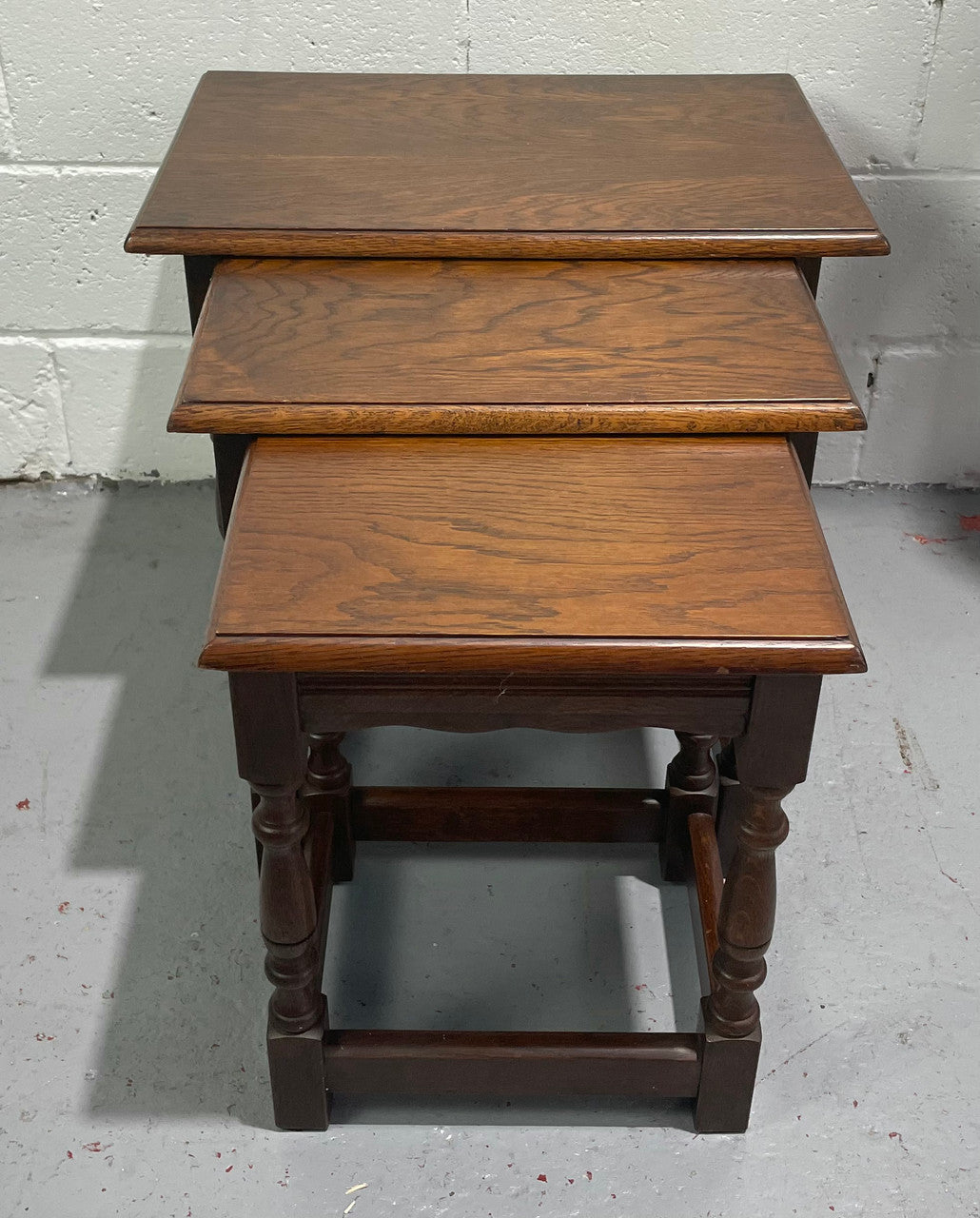 Tudor style English dark Oak nest of three tables. They are in good restored condition.