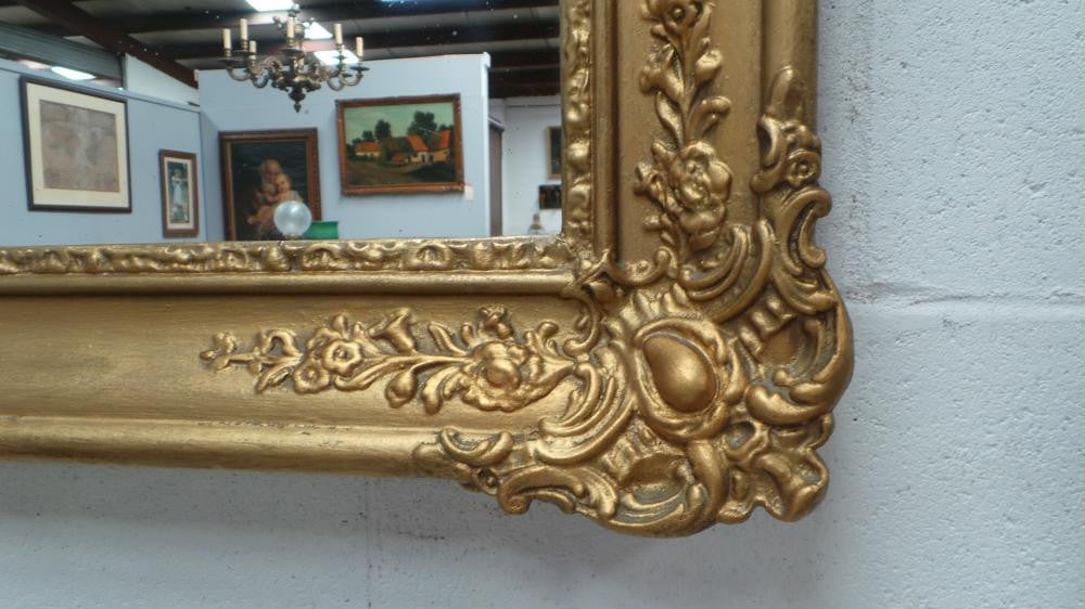 A French transitional Louis XV/Louis XVI style, gilded hanging wall mirror. In good restored condition.