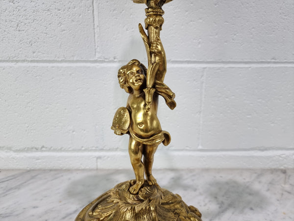 A pretty 19th Century French gilt bronze candelabra featuring a cherub. In good condition. Circa 1880.