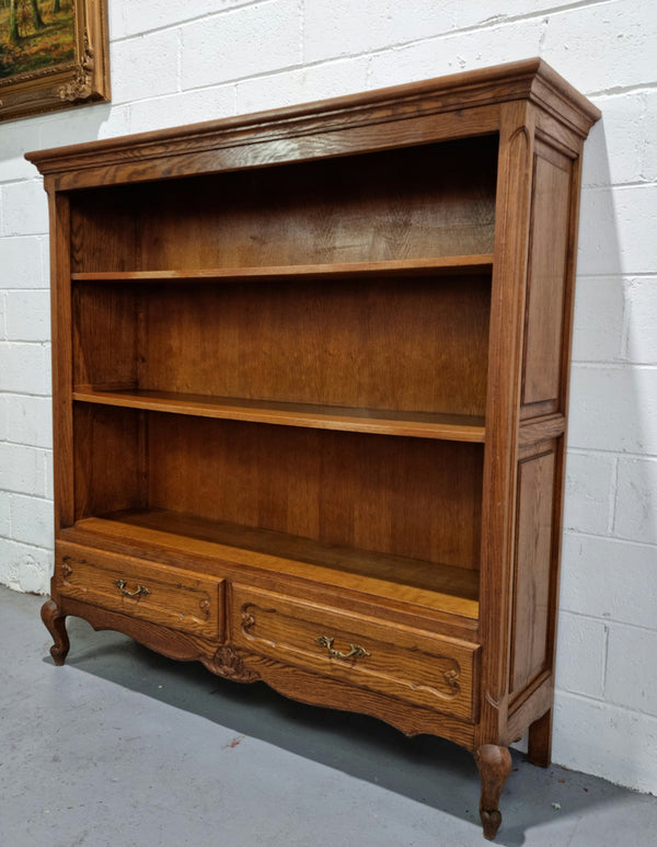 Lovely French Oak Louis XV style open shelf bookcase with two drawers for storage and three shelves in good original detailed condition.