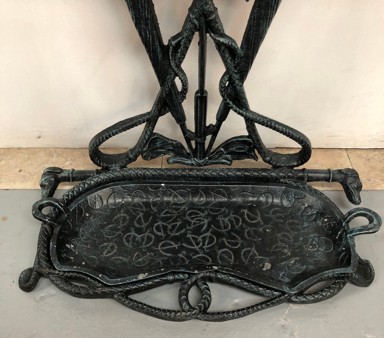 A black cast iron umbrella stand displaying a horse in the middle with four dogs on the side. In good original condition.