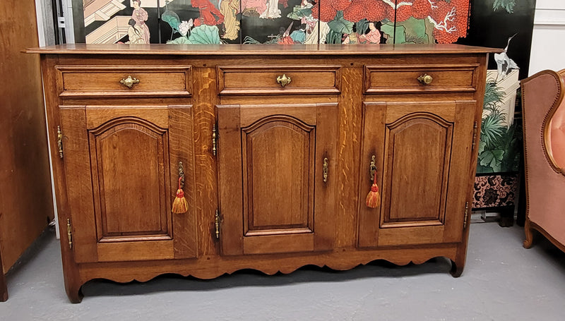 French Oak early 19th century three door buffet. It has a classic simple look and has three cupboards and three drawers. It is in good original detailed condition.