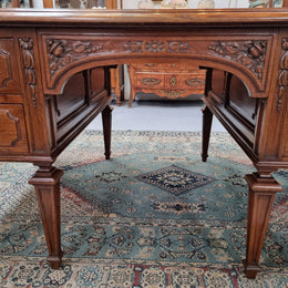 Substantial French Louis XVI style Oak partners desk. It has a beautiful leather top, two drawers on either side and decorative carvings throughout. Sourced from France and in good original detailed condition.
