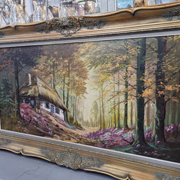 Vintage French oil painting on canvas in original gilt frame of "Forest Cottage Scene". Circa 1950's.