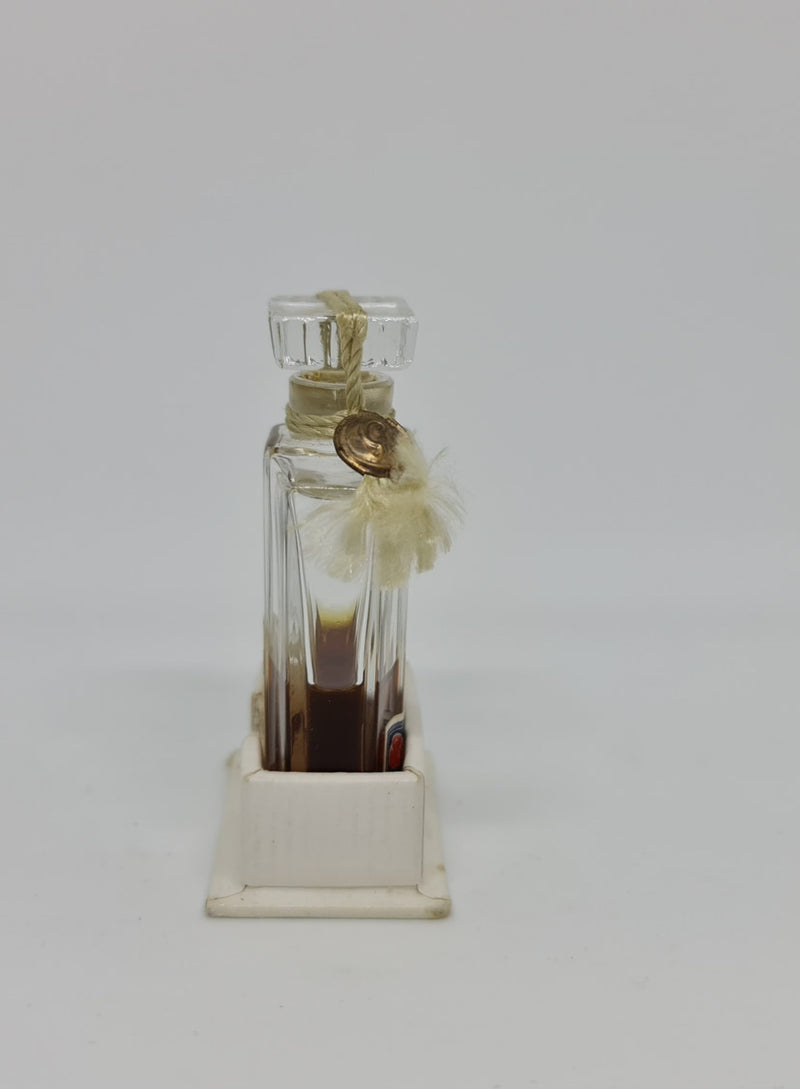 Vintage "Jicky" perfume bottle in great original condition with white base that it sits in.