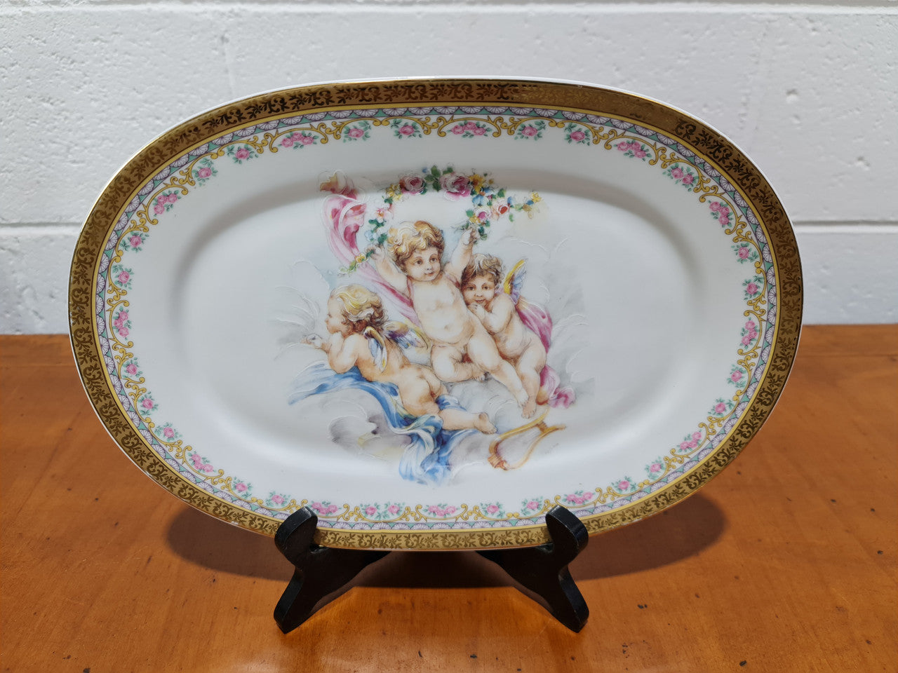 Beautiful T. Limoges porcelain decorative oval plate depicting 3 cherubs with gold edging. In good original condition.