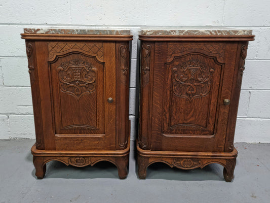 Lovely pair of French oak bedside cabinets with nicely carved details and marble tops. In good original detailed condition.