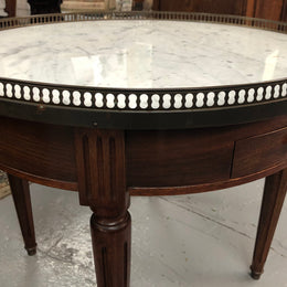 Large French Bouillotte table with a marble top and brass fitted gallery. It has two concealed leather - topped slides and two drawers and in good original condition.