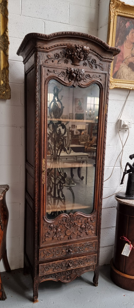 Petite oak armoire display cabinet with a glass door, two drawers at the bottom and three shelves inside. Late 18th Century and amazing detailed decorative carvings. Sourced from France and in good original condition.