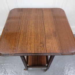 Oak drop leaf auto trolley on wheels. Both sides open up to make a larger table. It is in good original detailed condition.