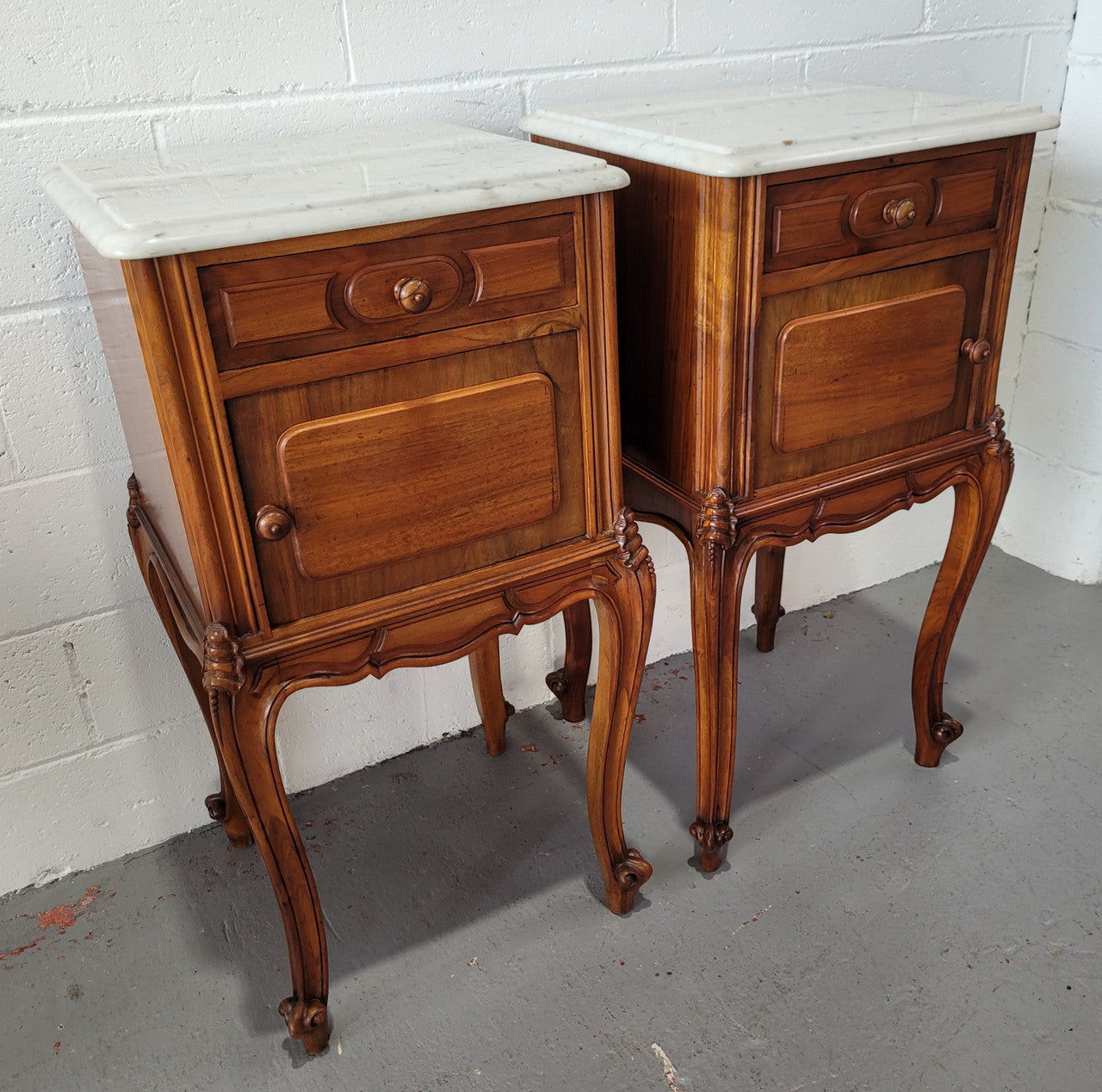 Pair of stunning Louis XV style French Walnut white marble top bedside cabinets. They have one drawer and a cupboard that is marble lined. The marble has been polished and they are in good original detailed condition.