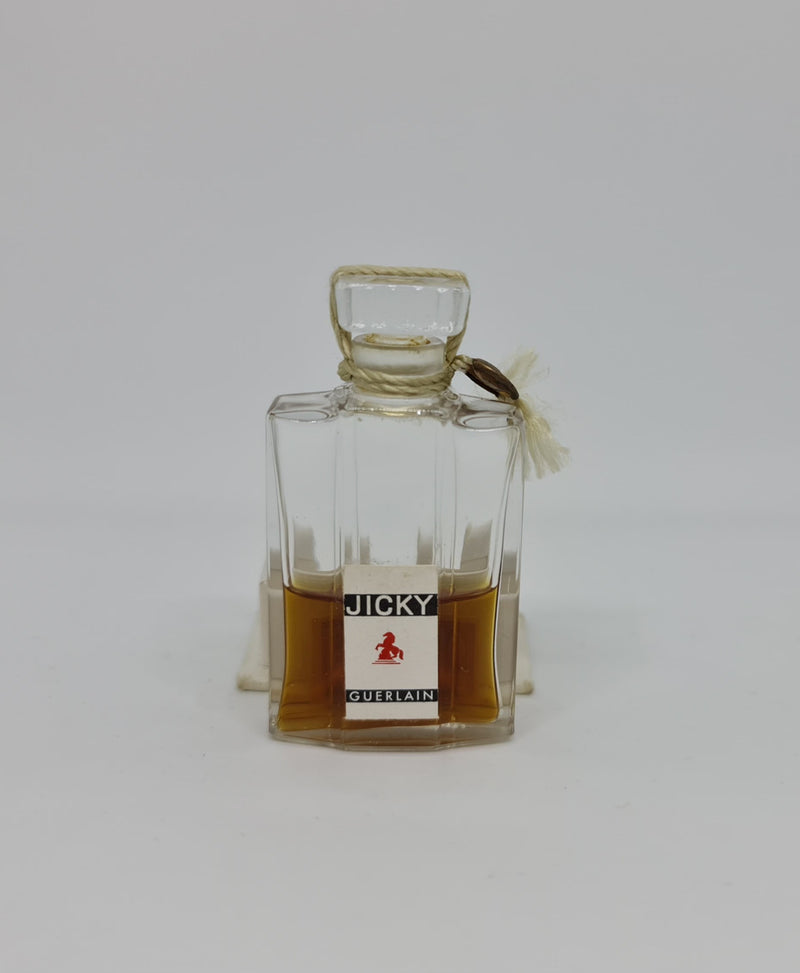 Vintage "Jicky" perfume bottle in great original condition with white base that it sits in.