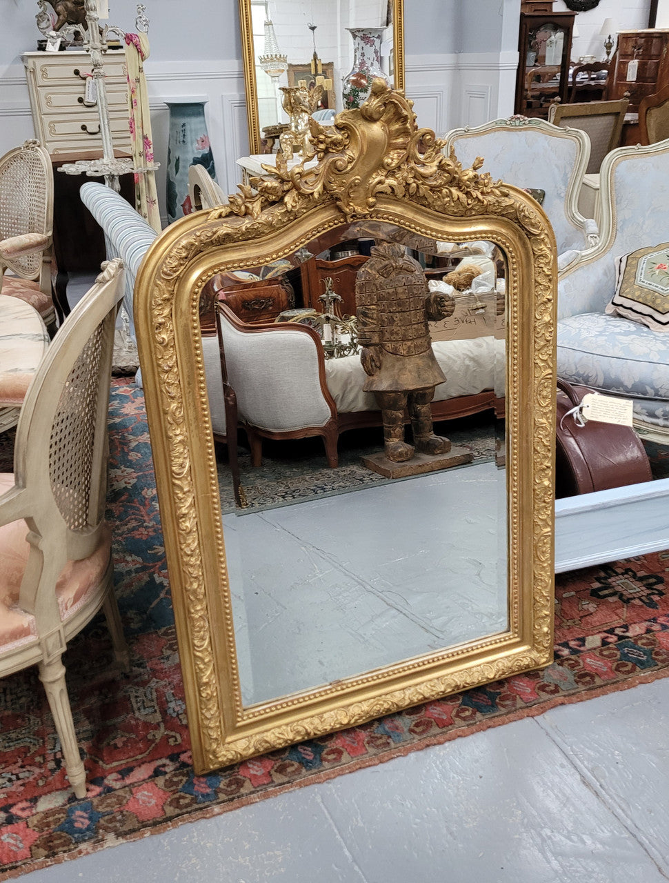 Beautiful French Napoleon III Louis XV style gilt framed bevelled mirror with an ornate crest on top. It has been sourced from France and is in good original detailed condition with the mirror showing signs of age.