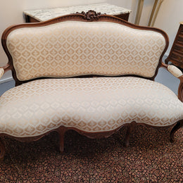 A late 19th Century French Walnut Louis XV style settee with a serpentine front. This settee upholstery is like new and is in very good condition.