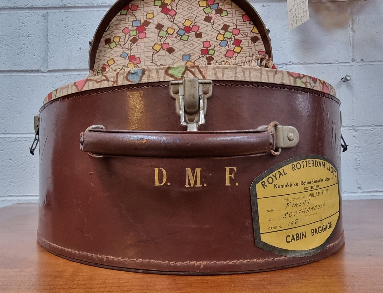 Charming solid leather hatbox with patterned fabric interior and two interior pockets. Interior stamp is for The Mutual Store Melbourne. Bears paper stamps for P&O Cruise Passenger” & “Peninsular  the top and D.M.F. in gold near the handle. Circa: Early 1900’s. 43 cm across and H:21 cm the lid.