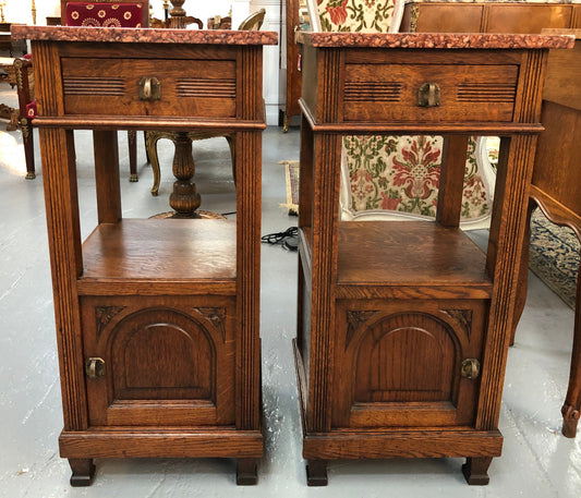 A pair of French Oak Arts and Crafts bedside cabinets with marble tops and a drawer and cupboard for storage in good condition.