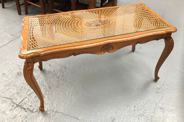 Lovely French Oak Louis XV style cane top coffee table with a glass top. In good original detailed condition.