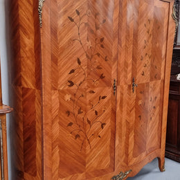 Charming French Louis XV Style Marquetry Inlaid Two Door Armoire. Features three adjustable shelves and ormolu trim. It has been sourced from France and is in good original condition.