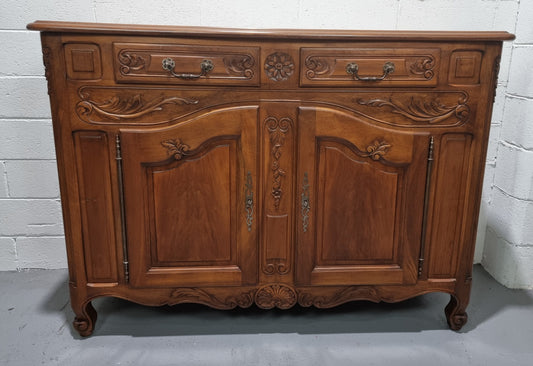 French Walnut two door buffet with parquetry top. It has two drawers and an adjustable shelf. In good original detailed condition and it has been sourced from France.