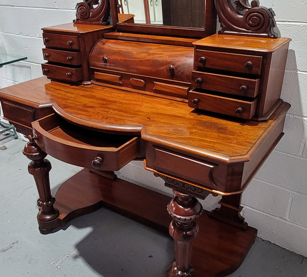 Beautiful Flame Mahogany Victorian duchess dressing table. Circa 1880 in date. It has a serpentine front outline and has an adjustable swing frame mirror. It is fitted with a central roll up storage section and then has three small drawers to either side, aswell as a central drawer in the middle of the serpentine front. It is in good original condition.