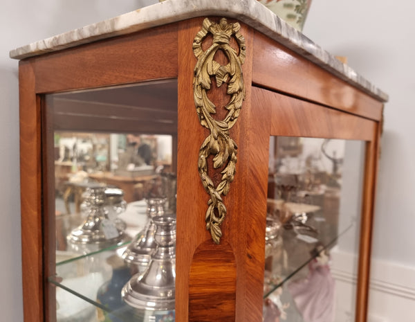 Beautiful French walnut inlaid vitrine with a lovely marquetry design and ormolu mounts. Has a beautiful coloured marble top and two glass shelves. In good original condition.