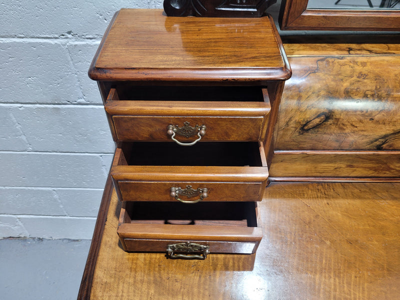 An elegant Victorian Figured Walnut dressing table with tilit mirror and a stunning fine Firgured Walnut serpentine shaped front. It has been sourced locally and is in good original detailed condition.