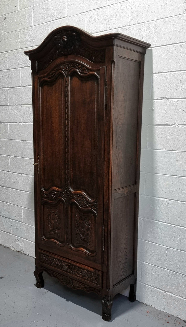 An Attractive French Louis XV style single-door ‘Marriage Armoire’. Beautifully arched crest with detailed carved flowers along with an arched single door which repeats the floral carvings. It is also has plenty of storage space with three adjustable shelves along with a drawer at the bottom. All in good original detailed condition.