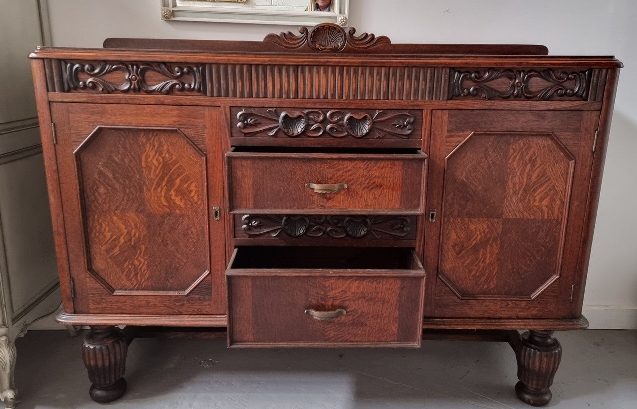 Art Deco Tudor style Oak sideboard with decorative carved detail. Plenty of storage space with two cupboards and four drawers. It has been sourced locally and is in good original detailed condition.