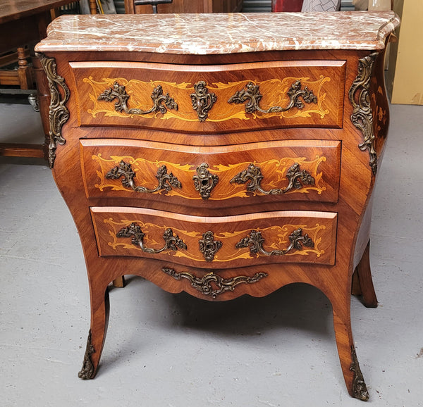 Antique French Louis XV style compact three drawer marble top commode with marquetry inlay and ormolu mounts. Sourced from France and in good original detailed condition.