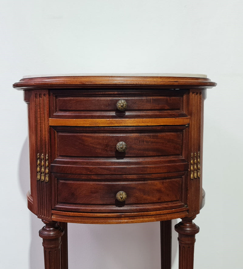 Round Louis XVI style Mahogany marble top side table. It has one drawer and a cupboard for storage. It is in good original detailed condition.