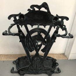 A black cast iron umbrella stand displaying a horse in the middle with four dogs on the side. In good original condition.