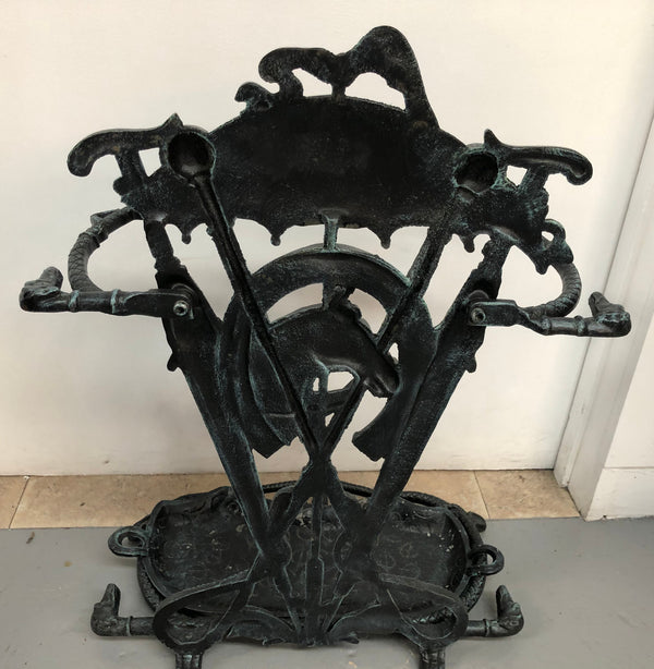 A black cast iron umbrella stand displaying a horse in the middle with four dogs on the side. In good original condition.