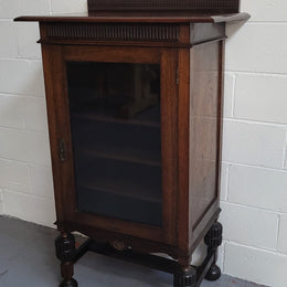 A very practical compact Oak Tudor style display cabinet with three fixed shelves. In good original detailed condition.