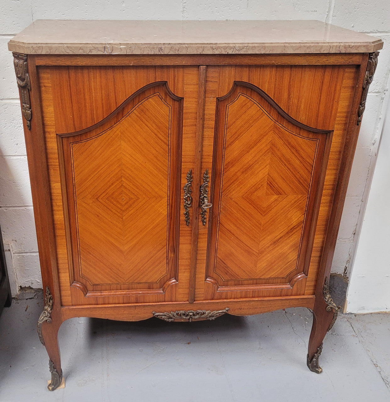 Stunning compact Louis 15th style two door walnut cabinet with ormolu trim and marble top. It is in good original condition.