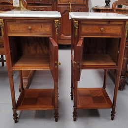Pair of white marble topped Louis 16th style bedside cabinets consisting of one drawer and one cupboard.  Inlaid with burr walnut and has decorative mounts. They have been sourced from France and are in good original condition.
